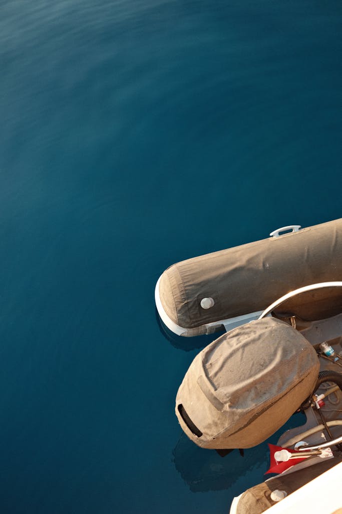 Close-up of an inflatable boat floating on calm, deep blue water.
